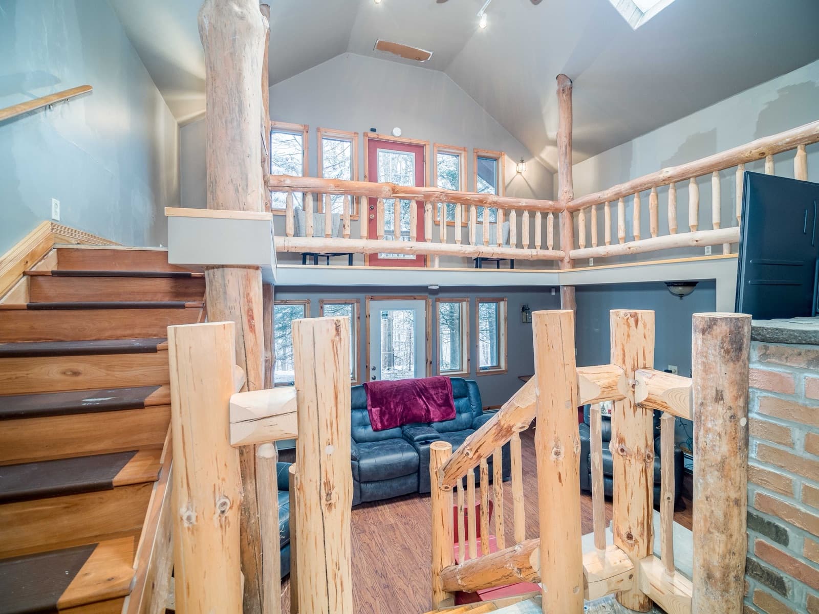 Vaulted great room with log railings and a loft
